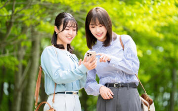 スマホ見ながら話す女性2人