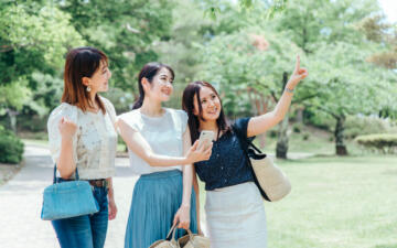 スマホ見ながら話す女性3人